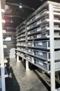 Custom metal shelving with plastic bins installed inside commercial van Custom metal shelving with plastic bins installed inside commercial van