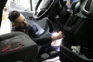 Worker performing a custom upfitting on a commercial van Worker performing a custom upfitting on a commercial van