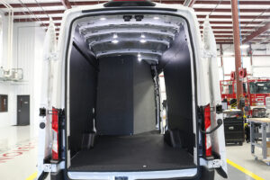 Custom bulkhead installed on white commercial van inside workstation Custom bulkhead installed on white commercial van inside workstation