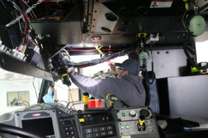 Worker installs custom David Clark harness layout inside an emergency vehicle Worker installs custom David Clark harness layout inside an emergency vehicle