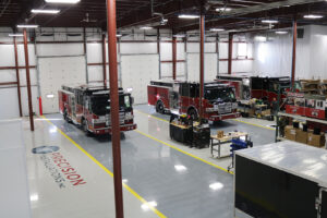 Workers install equipment on three emergency vehicles in workstations Workers install equipment on three emergency vehicles in workstations