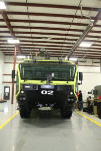 ARFF (airport firetruck) parked in workstation with worker for equipment installation ARFF (airport firetruck) parked in workstation with worker for equipment installation